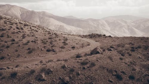Route sinueuse à travers le paysage aride du Pamir au Tadjikistan au crépuscule