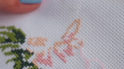 Extreme Close Up of Skilled Person Embroidering Fabric with Painted Nails