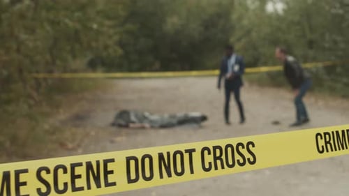 Police Investigators Examine a Covered Body at Crime Scene
