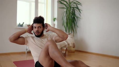 Man Doing Sit-ups on Yoga Mat Indoors