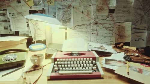 Bureau de machine à écrire et téléphone sous le panneau des preuves au bureau pendant la nuit