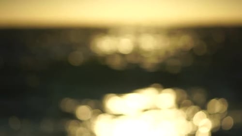 Blurred Golden Sea at Sunset The Sun Reflects and Sparkles on the Waves with Bokeh Illuminating the