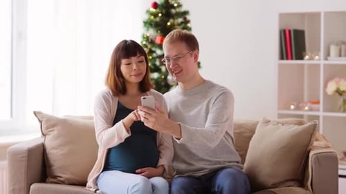 Pregnant Woman and Man Relaxing on Couch