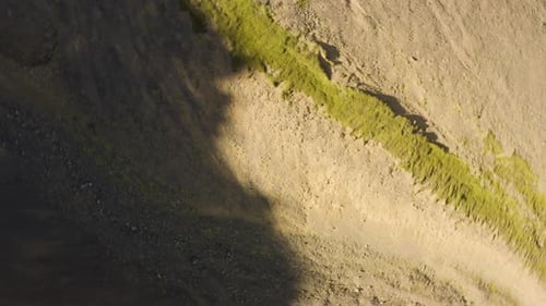 Erosion of Icelandic ridgeline in shadow of a mountian, spiral rise top-down view