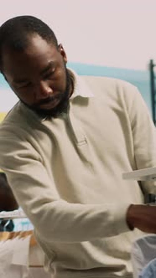 Man Holding Shirts on Hangers at Work
