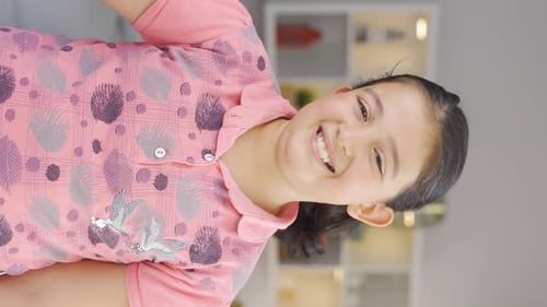 Vertical video of Girl child showing mind to camera.