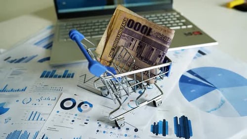Miniature Shopping Cart Full of Currency on Desk