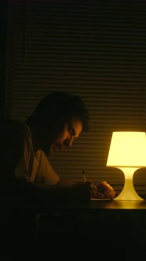 Thoughtful Man Writing a Letter at Night