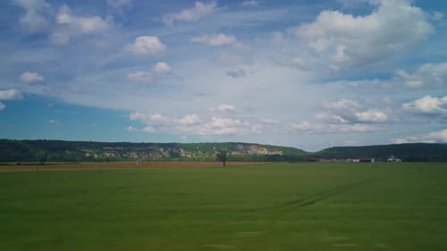 Blick aus dem Fenster des Hochgeschwindigkeitszuges Schöne Fahrt mit ländlicher Landschaft, Wolken Ein Blick auf