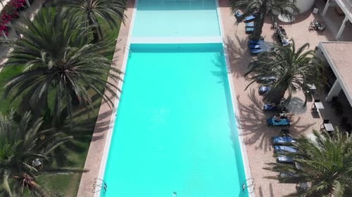 Drohne fliegt über den schönen Hotel-/Resortpool. Leute, die sich im Urlaub entspannen. 4k, 30fps, Vogelperspektive m