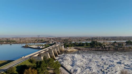 Majestosa onda de água de cima enquanto a barragem libera torrentes na paisagem