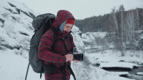 Young Man With Camera in Winter Wilderness