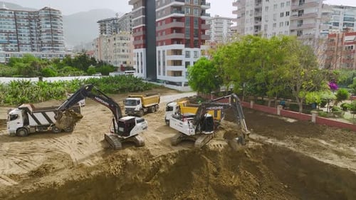 Excavators Loading Dump Trucks at Construction Site