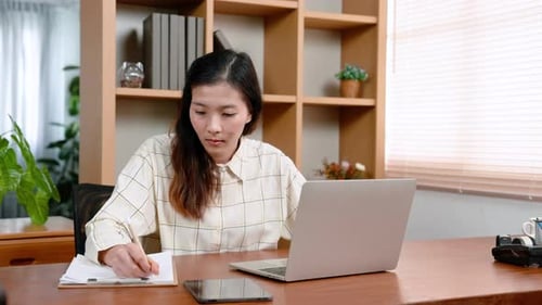 Young Adult Woman Working at Desk With Laptop