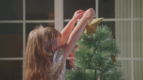 Young Child Decorates Christmas Tree with Santa Ornament