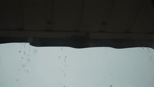 Rain Streaks Down a Window on Overcast Day