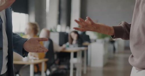 Closeup of Men Gesturing Shaking Hands Expressing Cooperation and Unity in Coworking Center