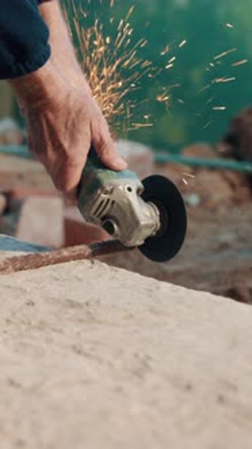 Persona, manos y construcción con amoladora sobre barras de acero para refuerzo o ingeniería civil