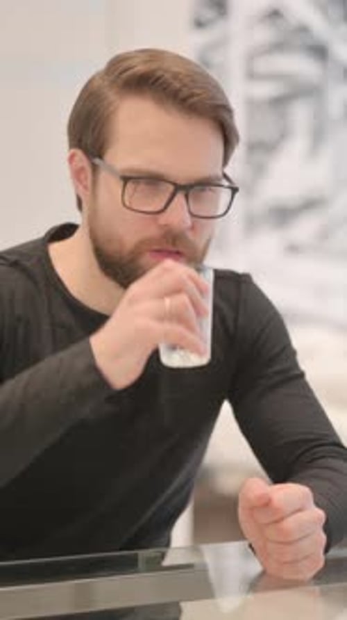 Man Drinking Glass of Water in Minimalist Setting