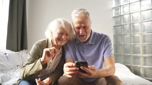 Senior Couple Enjoying Smartphone Together at Home