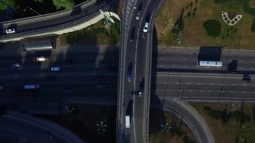 Cars and transport motion on highway interchange in summer city top view
