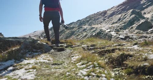 Low angle shot of photographer walking through mountain with melting fresh snow