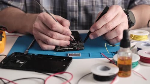 Master In The Repair Center Fixes A Broken Smartphone