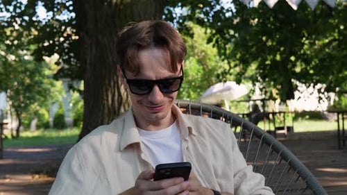 Man Relaxing in Park with Smartphone