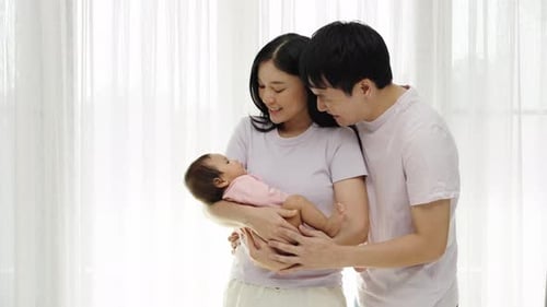 Loving Family Cradling Newborn Baby Indoors