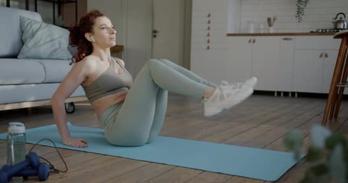 Woman Doing Leg Lifts on Yoga Mat at Home