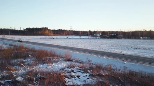 A Scenic Winter Road Meanders Through a Breathtaking Snowy Landscape Embellished with a Beautiful