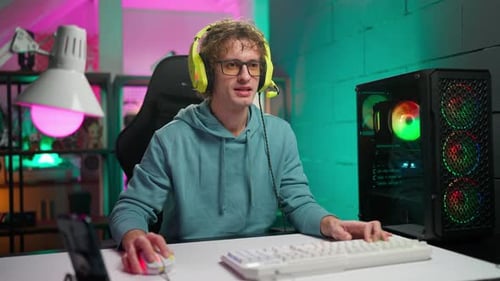 Young Adult Gaming With Neon Lights at Desk