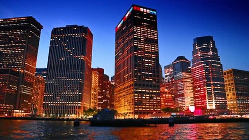 High-rises of Manhattan at the waterfront of the East River at night time.
