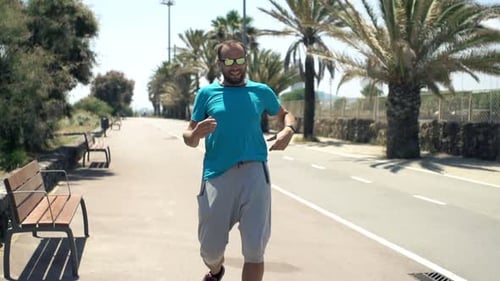 Man Jogging And Checking Pulse On Smartwatch In City Park