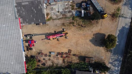 Mobile crane stands waiting to lift steel at a warehouse. Crane operators and mobile cranes