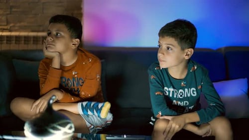 Boys Watching TV on Sofa at Night