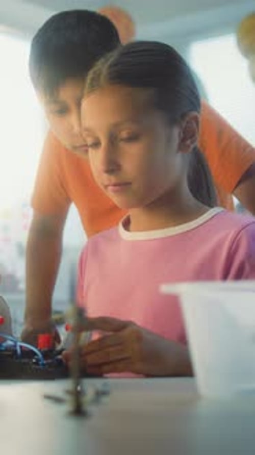 Girl and Boy Working on Robotics Project