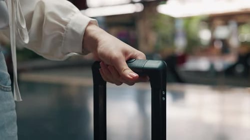 Woman Tourist Hand Holds Suitcase Handle Walking Along Railroad Platform Closeup