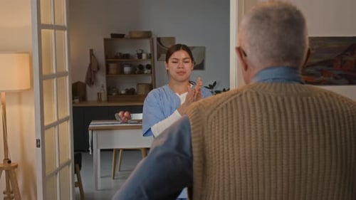 Caregiver Leads Gentle Exercise for Senior Couple Indoors