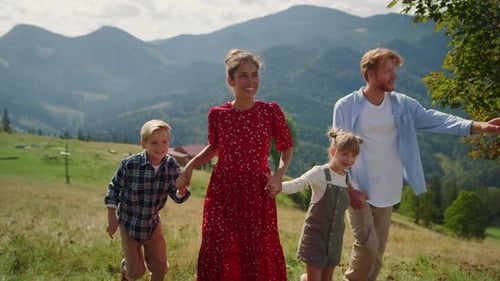 Happy Walking Family Enjoying Summer Vacation on Beautiful Hill. Cheerful Couple Spending