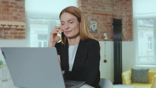 Happy Businesswoman Speaking on Smartphone Use Laptop Computer at Home Office Successful Connection