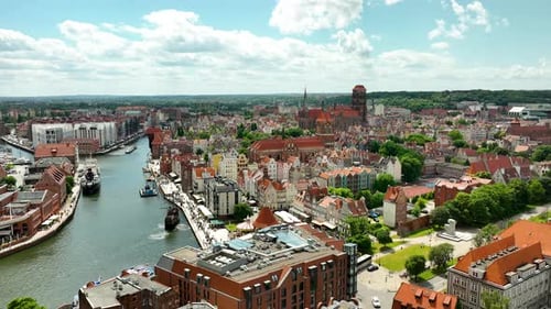 Aerial view of Gdańsk old town, featuring historical buildings and the Motława River under a bright