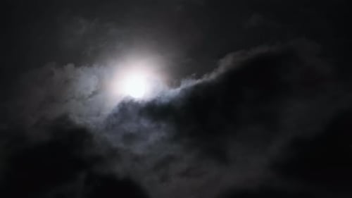 Full Moon Shining Through Dark Moody Clouds