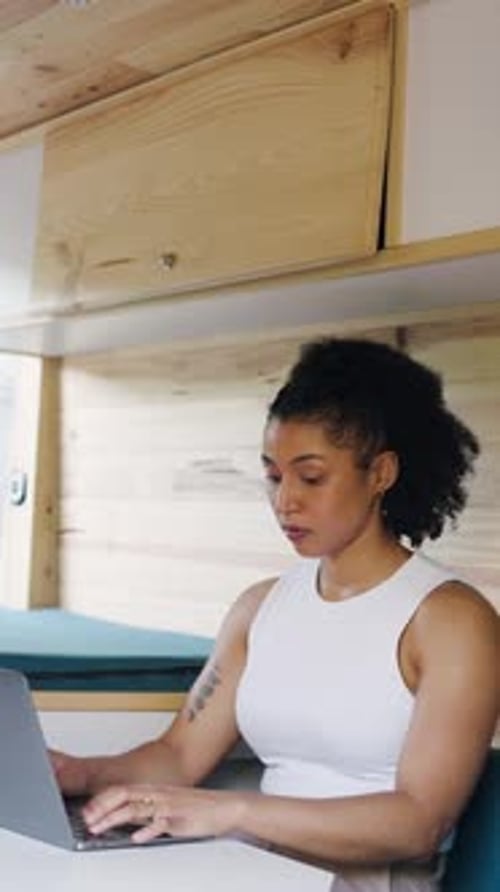 Woman Working on Laptop Inside Converted Camper Van