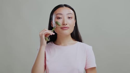 Woman Using Jade Roller Facial Massage Beauty Treatment