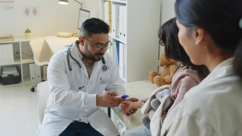 Male Pediatrician Measuring Temperature of Little Girl in Office