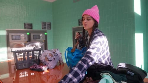 Young Woman Sorting Laundry at Laundromat