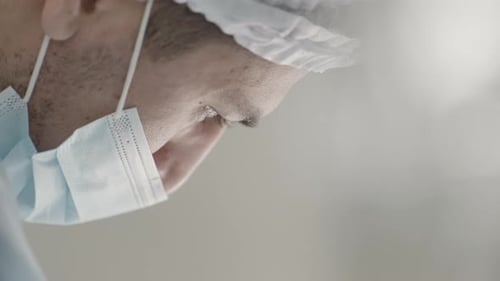 Medical surgeon in operating theater performing operation and looking down