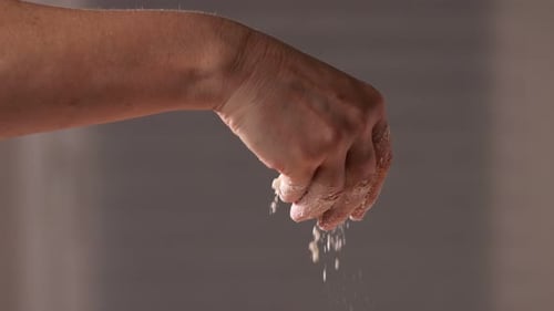 Hand of Mature Woman Pouring Flour on Table for Bakery