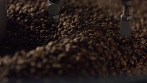 Coffee beans mixing in roasting machine, workshop production